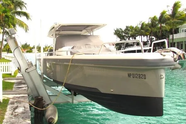 The Image of 2018 Axopar 37 Sun-Top boat docked on a lift in a tropical marina setting. - 0
