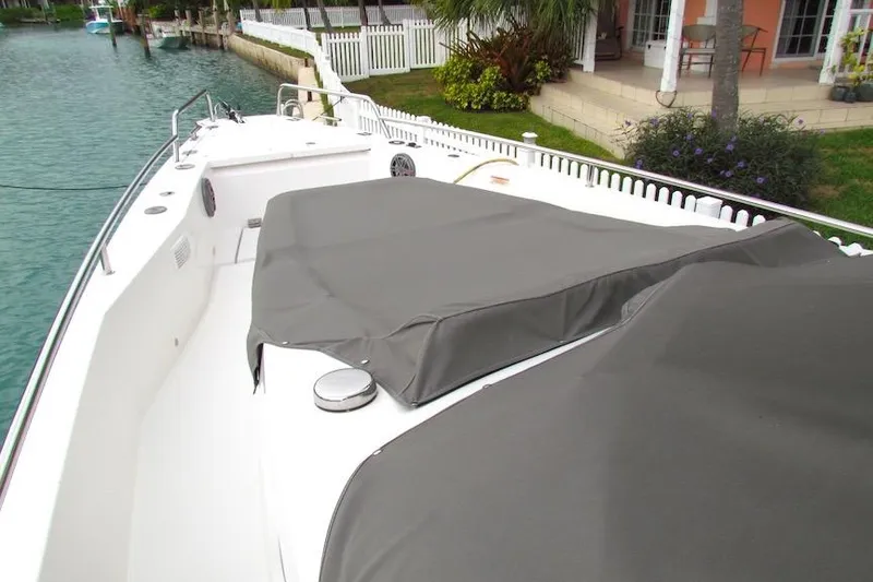 Slide: The Image of 2018 Axopar 37 Sun-Top boat with covered seating area by waterfront. - 12