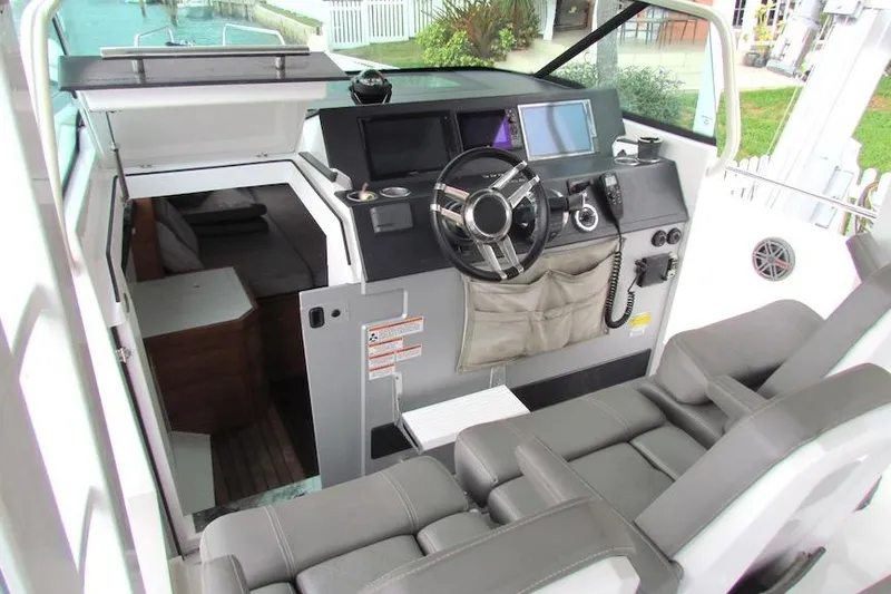 Slide: The Image of 2018 Axopar 37 Sun-Top boat interior with steering wheel and seating area. - 13