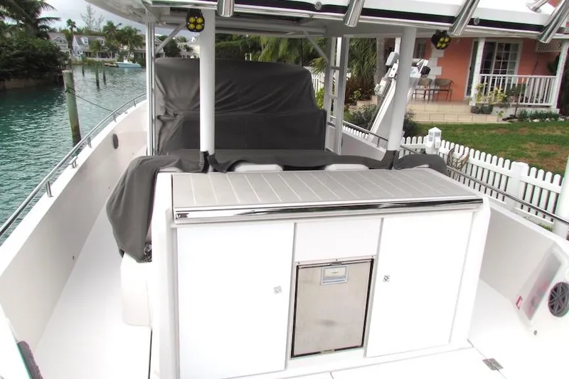 Slide: The Image of 2018 Axopar 37 Sun-Top boat with covered seating, docked near waterfront home. - 17