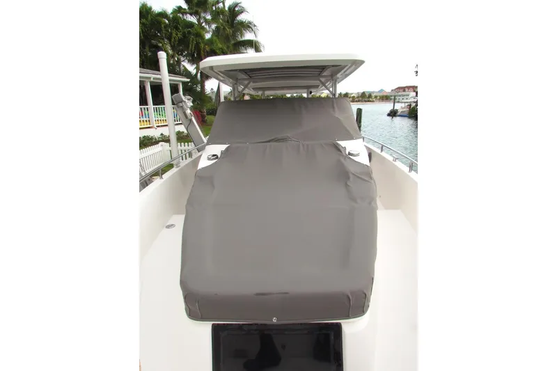 Slide: The Image of 2018 Axopar 37 Sun-Top boat with covered seating area, docked near waterfront homes. - 19