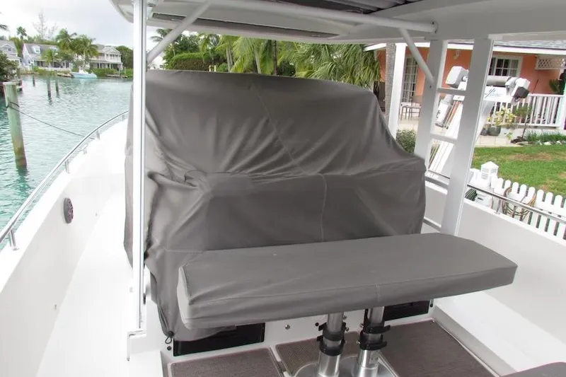 Slide: The Image of 2018 Axopar 37 Sun-Top boat with covered seating area, docked near waterfront homes. - 20