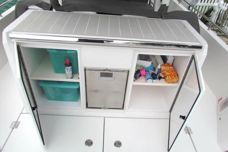 Slide: The Image of Storage compartments on a 2018 Axopar 37 Sun-Top boat, featuring organized shelves and supplies. - 26