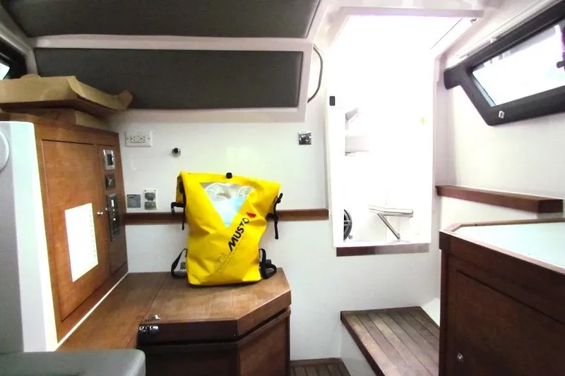Slide: The Image of Interior of 2018 Axopar 37 Sun-Top boat with wooden cabinetry and yellow Musto bag. - 30