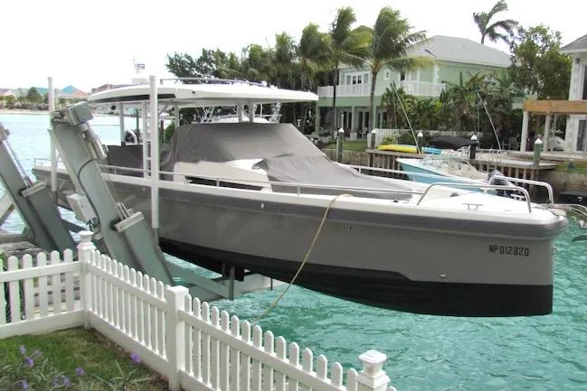 Slide: The Image of 2018 Axopar 37 Sun-Top boat docked by waterfront homes, surrounded by palm trees. - 4