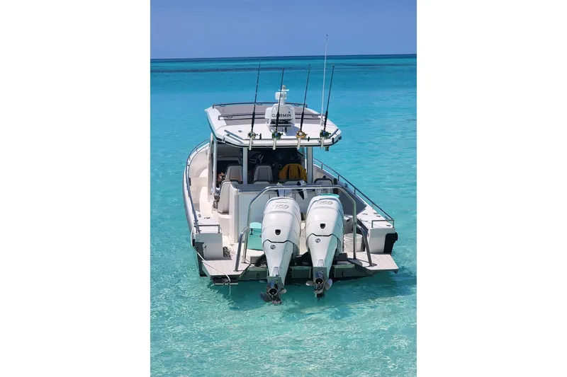 Slide: The Image of 2018 Axopar 37 Sun-Top boat with twin engines on clear turquoise water. - 6