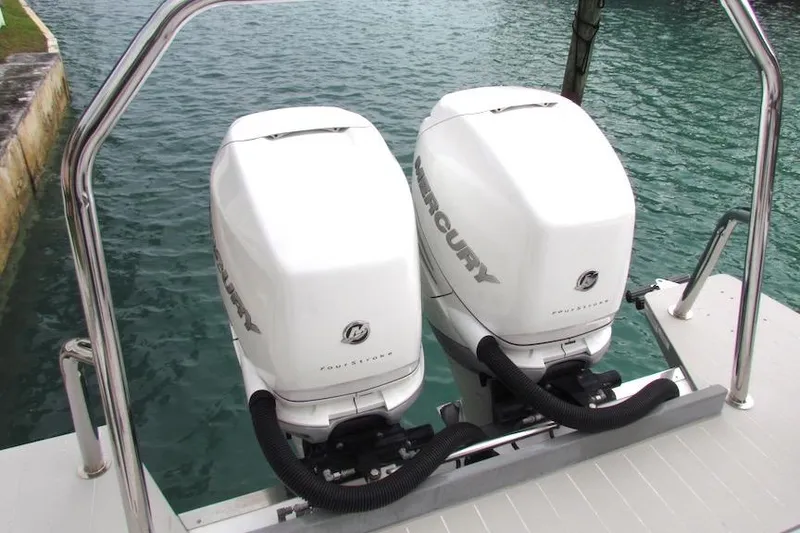 Slide: The Image of Twin Mercury outboard engines on a 2018 Axopar 37 Sun-Top boat, docked by the water. - 9