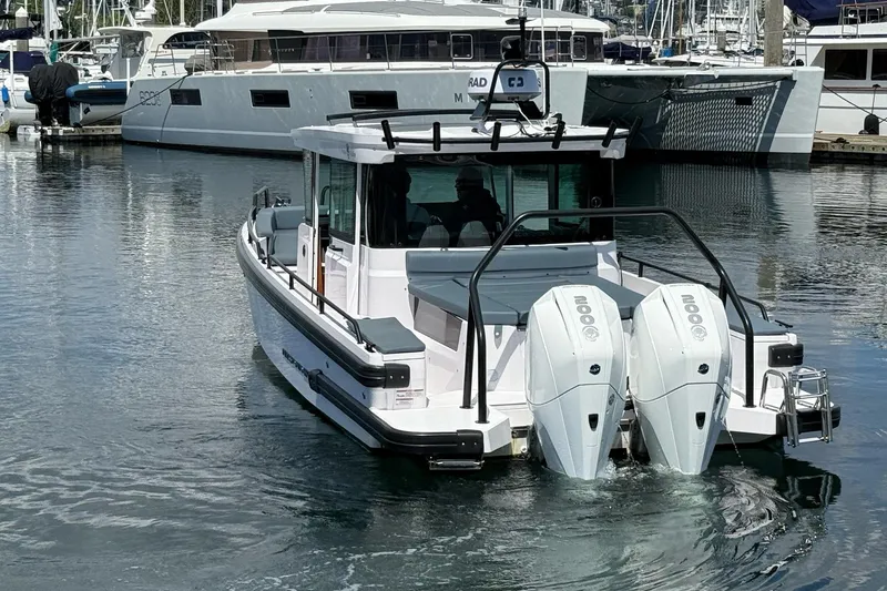 Slide: The Image of 2022 Axopar Brabus 28 Cabin boat with dual engines docked in a marina. - 12