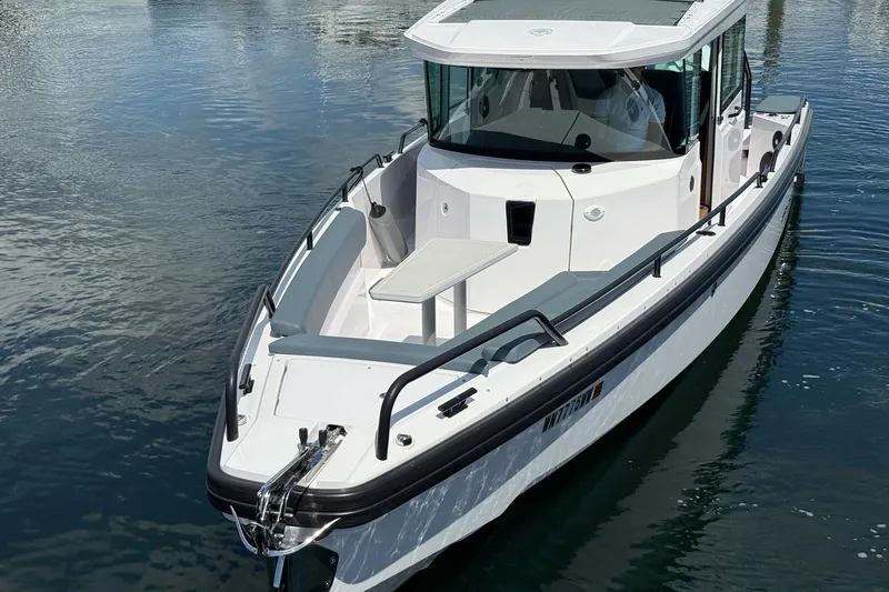 Slide: The Image of 2022 Axopar Brabus 28 Cabin boat on calm water, showcasing sleek design and modern features. - 18