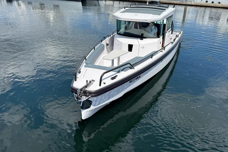 Slide: The Image of 2022 Axopar Brabus 28 Cabin boat on calm water, showcasing sleek design. - 19