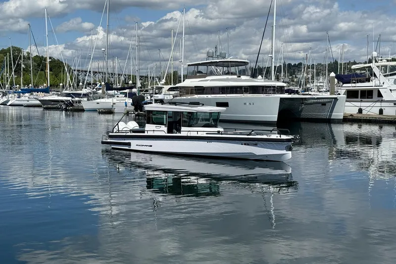 Slide: The Image of 2022 Axopar Brabus 28 Cabin boat docked in a marina with other yachts. - 2