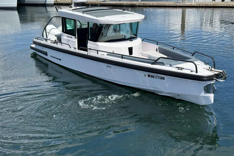 Slide: The Image of 2022 Axopar Brabus 28 Cabin boat on calm water, showcasing sleek design. - 21