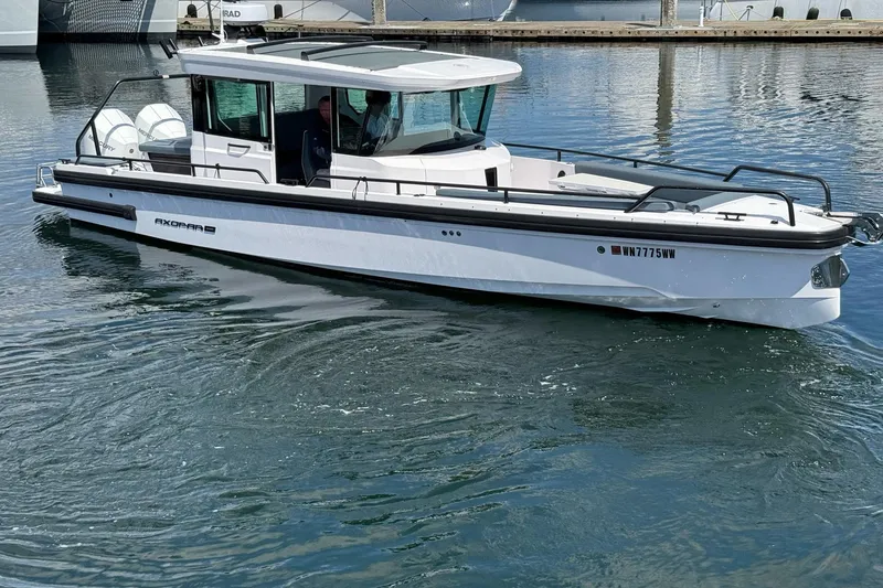 Slide: The Image of 2022 Axopar Brabus 28 Cabin boat on calm water, showcasing sleek design and modern features. - 22