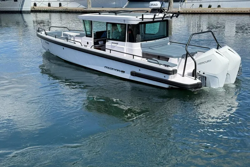 Slide: The Image of 2022 Axopar Brabus 28 Cabin boat on calm water, featuring sleek design and Mercury engines. - 25