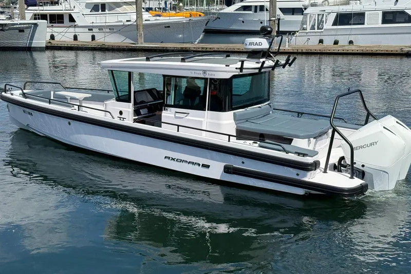 Slide: The Image of 2022 Axopar Brabus 28 Cabin boat docked in marina, featuring sleek design and Mercury engine. - 26