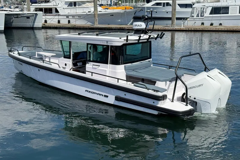 Slide: The Image of 2022 Axopar Brabus 28 Cabin boat with Mercury engines docked in a marina. - 27