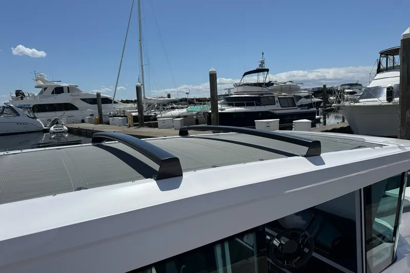 Slide: The Image of 2022 Axopar Brabus 28 Cabin boat docked at a marina under clear blue skies. - 37