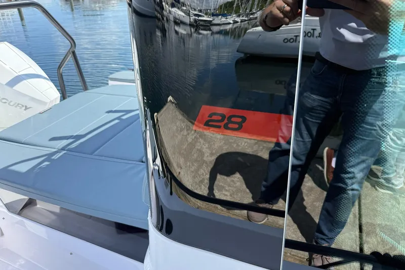 Slide: The Image of 2022 Axopar Brabus 28 Cabin boat with reflective surface and dockside view. - 38