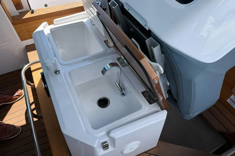 Slide: The Image of 2022 Axopar Brabus 28 Cabin boat sink with wooden cover and faucet. - 50