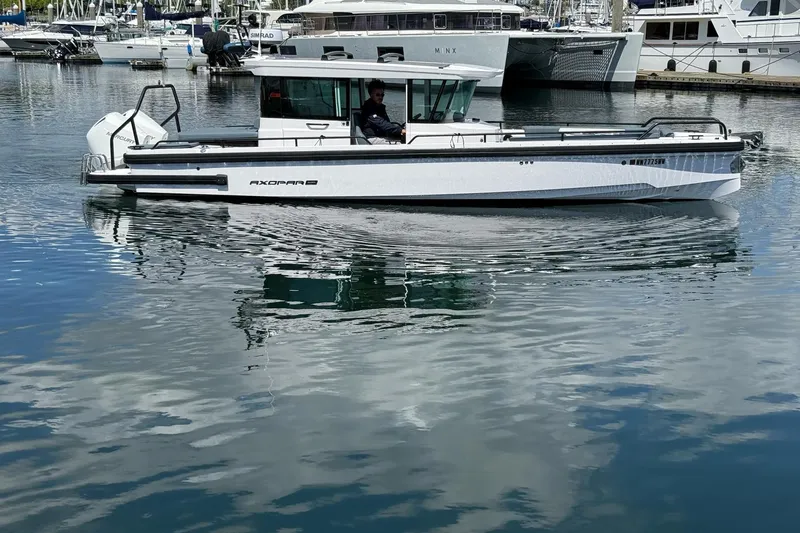 Slide: The Image of 2022 Axopar Brabus 28 Cabin boat on calm marina waters. - 6