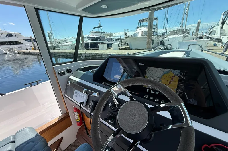 Slide: The Image of Interior view of 2022 Axopar Brabus 28 Cabin boat dashboard at marina. - 66