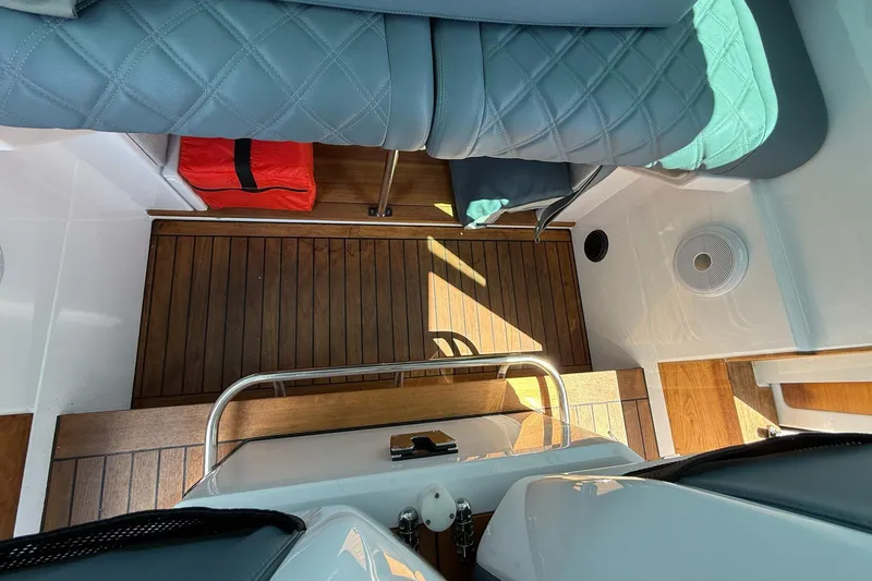 Slide: The Image of Interior of 2022 Axopar Brabus 28 Cabin with wood flooring and cushioned seating. - 67