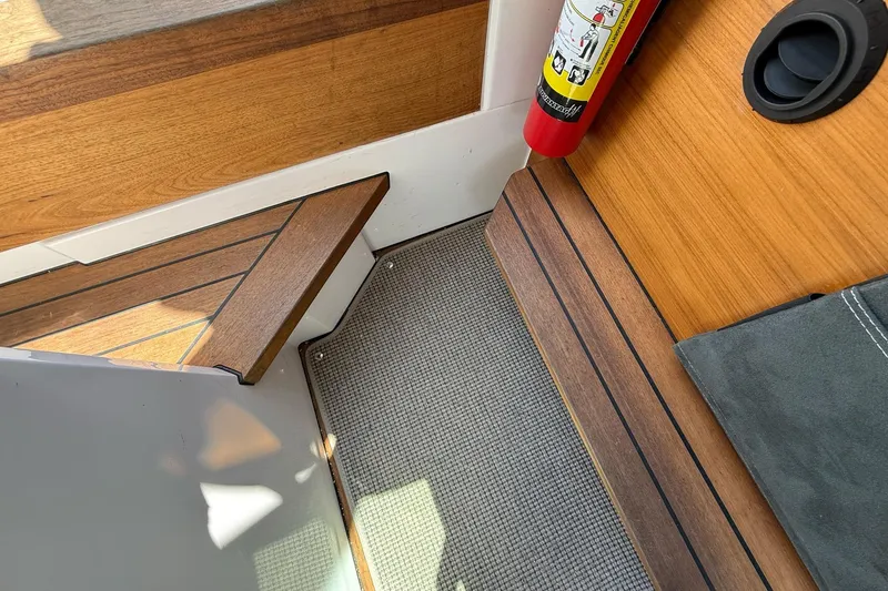 Slide: The Image of Interior of 2022 Axopar Brabus 28 Cabin with wood accents and fire extinguisher. - 68