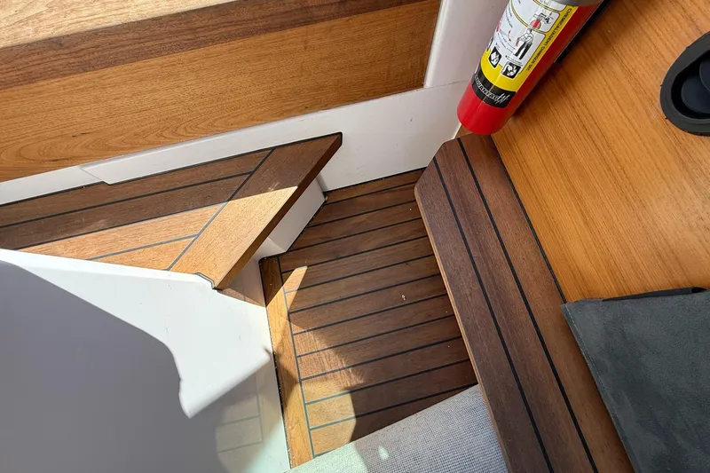 Slide: The Image of Interior of 2022 Axopar Brabus 28 Cabin with wooden flooring and fire extinguisher. - 69