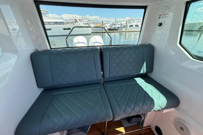 Slide: The Image of Interior of 2022 Axopar Brabus 28 Cabin with quilted seating and marina view. - 72
