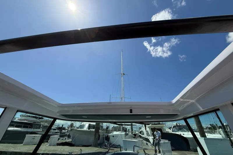 Slide: The Image of 2022 Axopar Brabus 28 Cabin with open roof, docked under clear blue sky. - 74