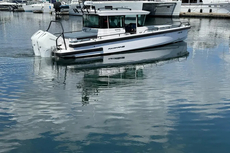 Slide: The Image of 2022 Axopar Brabus 28 Cabin boat on calm marina waters. - 8