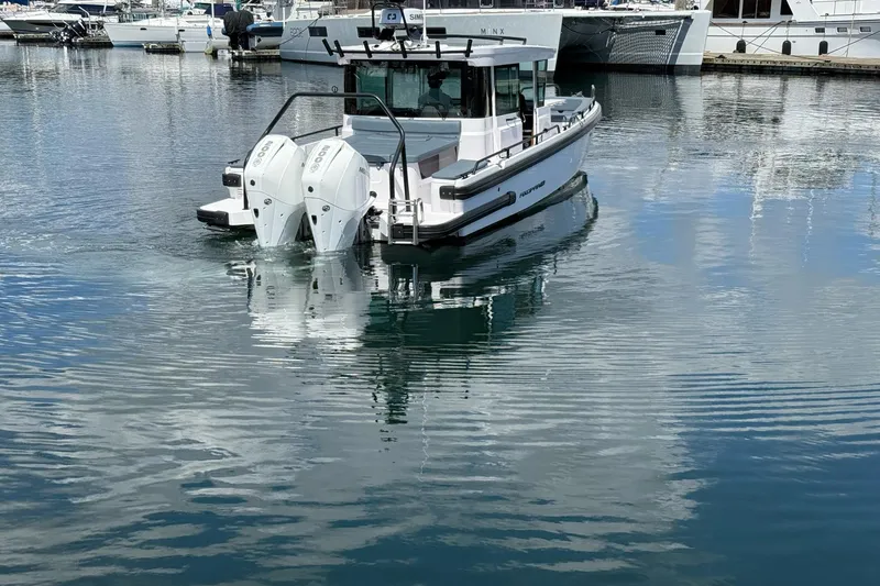 Slide: The Image of 2022 Axopar Brabus 28 Cabin boat on calm marina waters. - 9