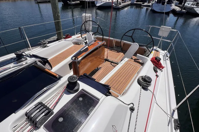 Slide: The Image of 2019 Dehler 34 sailboat cockpit with dual steering wheels and teak decking at marina. - 10