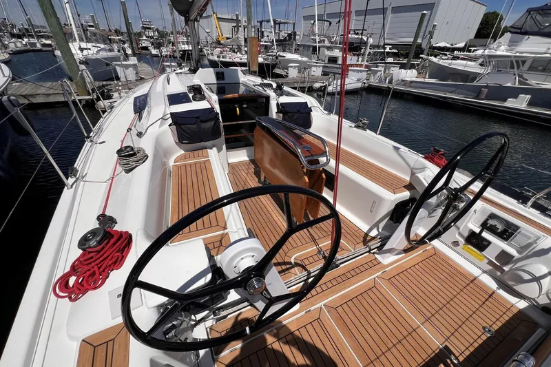 Slide: The Image of 2019 Dehler 34 sailboat cockpit with dual steering wheels and teak decking at marina. - 12