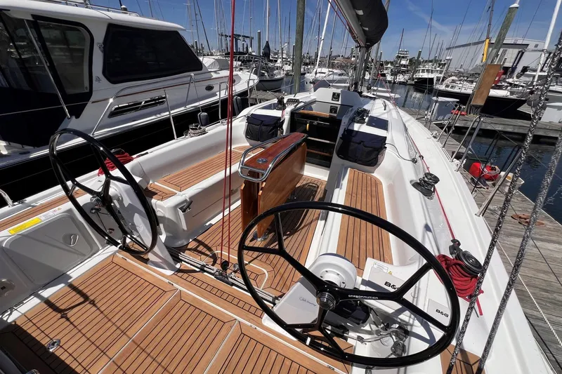 Slide: The Image of 2019 Dehler 34 sailboat cockpit with dual steering wheels, docked at a marina. - 13