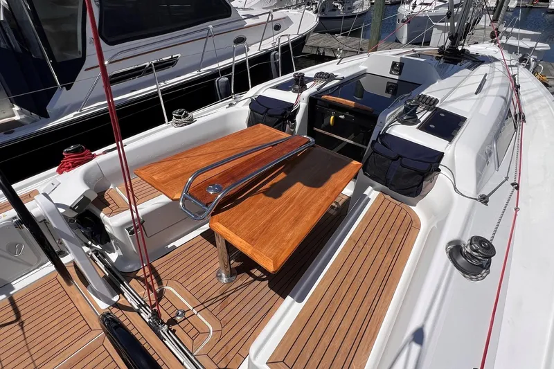 Slide: The Image of 2019 Dehler 34 sailboat cockpit with wooden table and seating, docked at marina. - 14