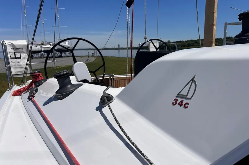 Slide: The Image of 2019 Dehler 34c sailboat deck with steering wheel and winches, docked near water. - 23