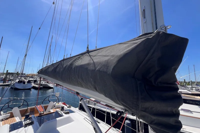 Slide: The Image of 2019 Dehler 34 sailboat with covered mainsail, docked in a marina under clear blue skies. - 28