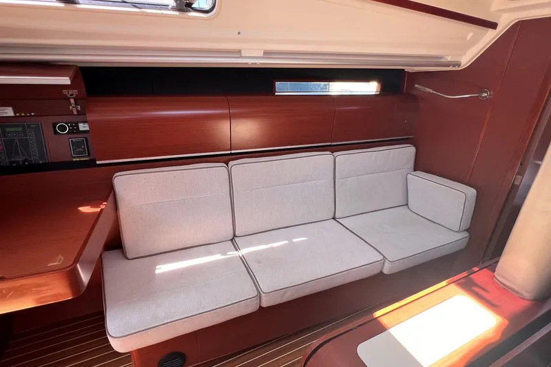 Slide: The Image of Interior of 2019 Dehler 34 yacht with cushioned seating and wooden finishes. - 36