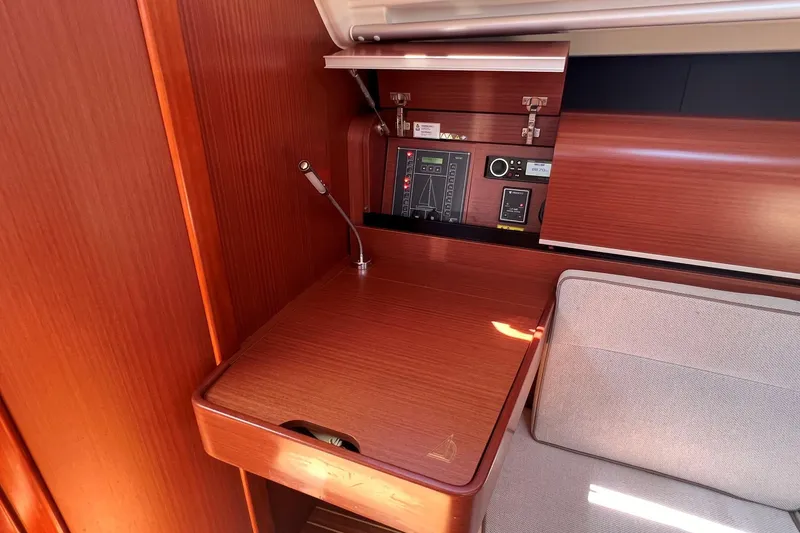 Slide: The Image of 2019 Dehler 34 yacht interior with wooden navigation station and control panel. - 43