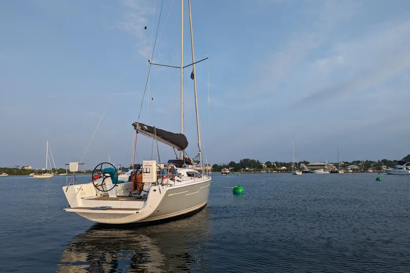 Slide: The Image of 2019 Dehler 34c sailboat anchored on calm water under a clear blue sky. - 7
