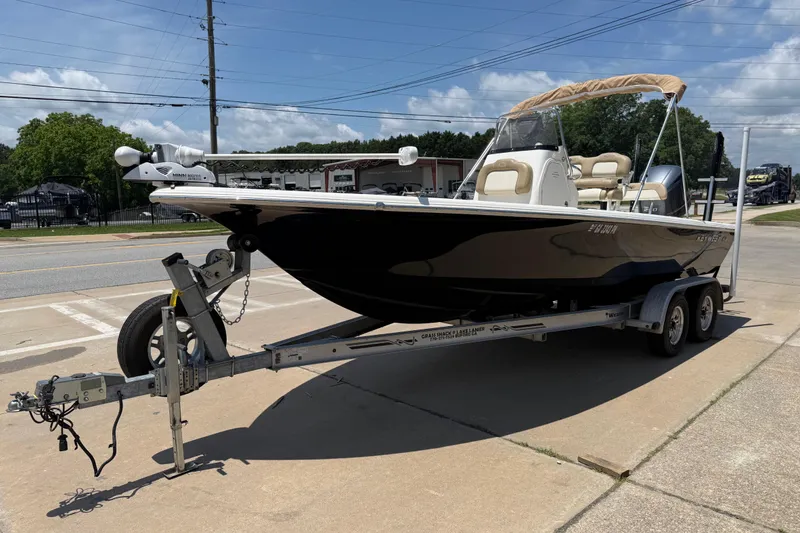 Slide: The Image of 2019 Key West 230 Bay Reef boat on trailer, parked outdoors under clear sky. - 4