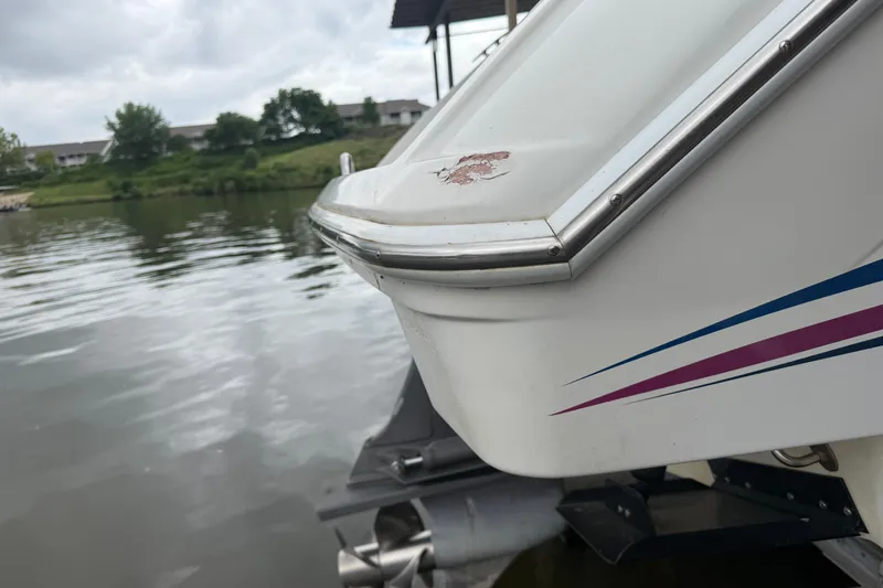 Slide: The Image of 1998 Formula 280 Sun Sport boat stern with minor damage, docked on a calm lake. - 20