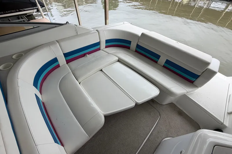 Slide: The Image of 1998 Formula 280 Sun Sport boat interior with white and striped seating by the water. - 4