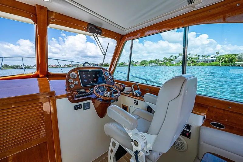 Slide: The Image of Helm of 2016 Hinckley Picnic Boat 37 MKIII with luxurious wood finish and waterfront view. - 14