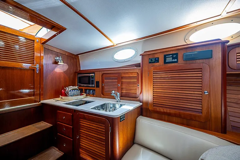 Slide: The Image of Luxurious 2016 Hinckley Picnic Boat 37 MKIII interior with wooden cabinetry and modern amenities. - 15