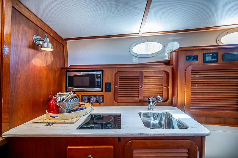 Slide: The Image of Luxurious galley of 2016 Hinckley Picnic Boat 37 MKIII with wood cabinetry and modern appliances. - 16