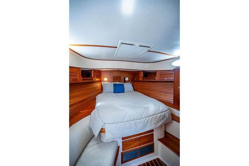 Slide: The Image of 2016 Hinckley Picnic Boat 37 MKIII cabin with cozy bed and wooden interior. - 17