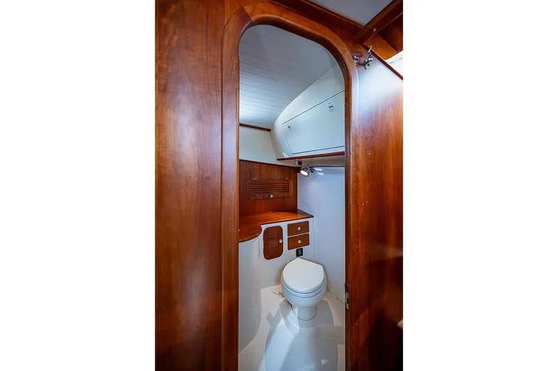Slide: The Image of 2016 Hinckley Picnic Boat 37 MKIII bathroom with wooden cabinetry and white fixtures. - 18