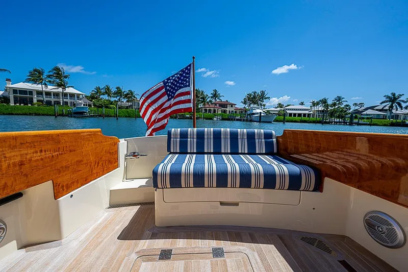 Slide: The Image of 2016 Hinckley Picnic Boat 37 MKIII with striped seating and American flag on a sunny day. - 5